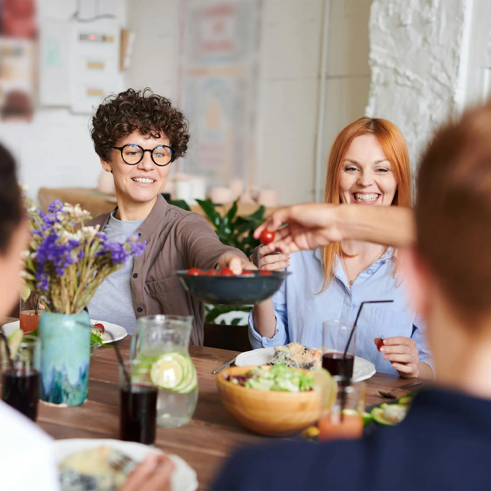 Friends sharing a meal at a dining table, enjoying a joyful Soda Water